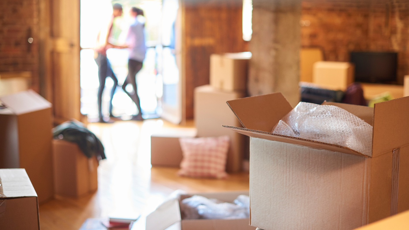 A room filled with boxes and a woman standing in the doorway